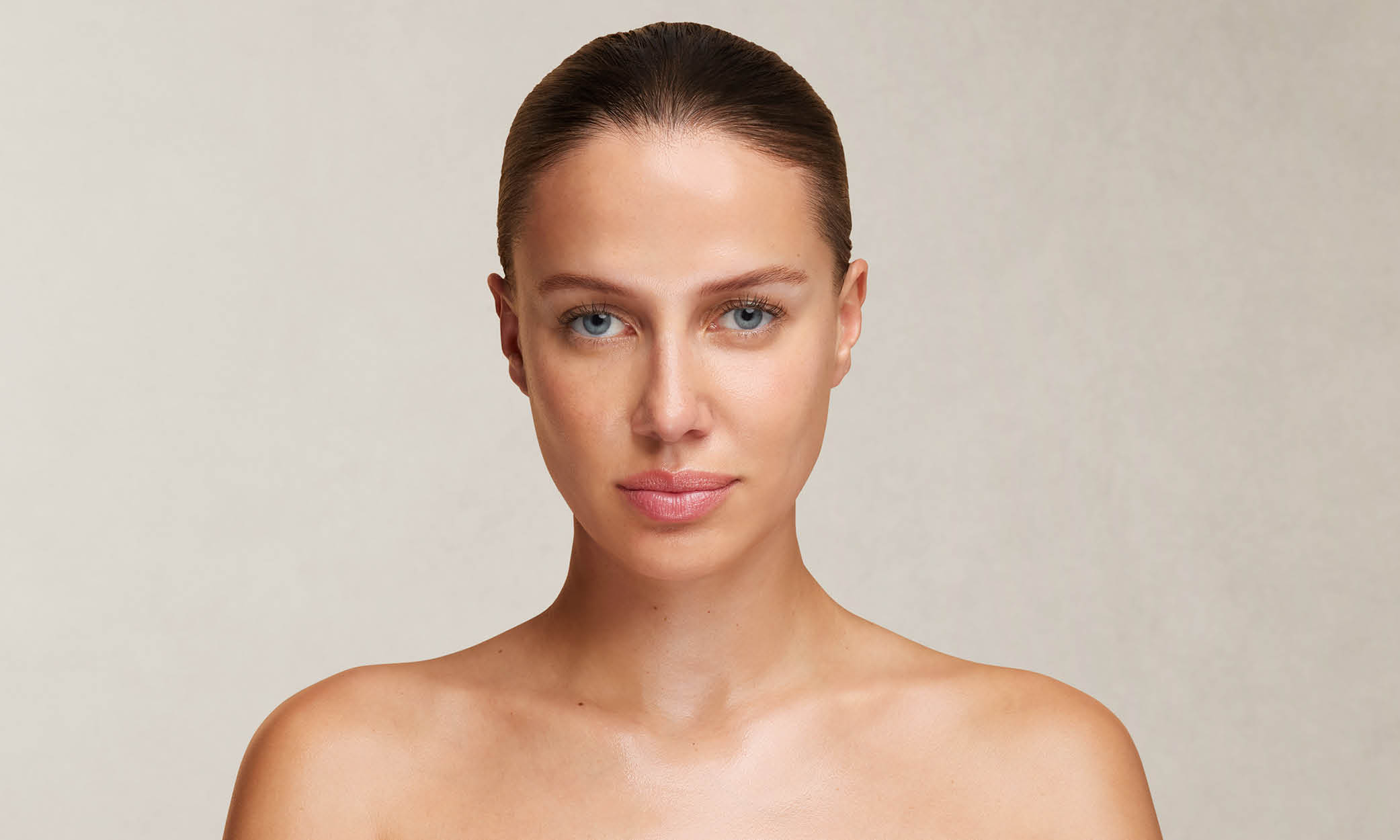 Frau mit zurückgebundenem Haar und nackten Schultern im Porträt