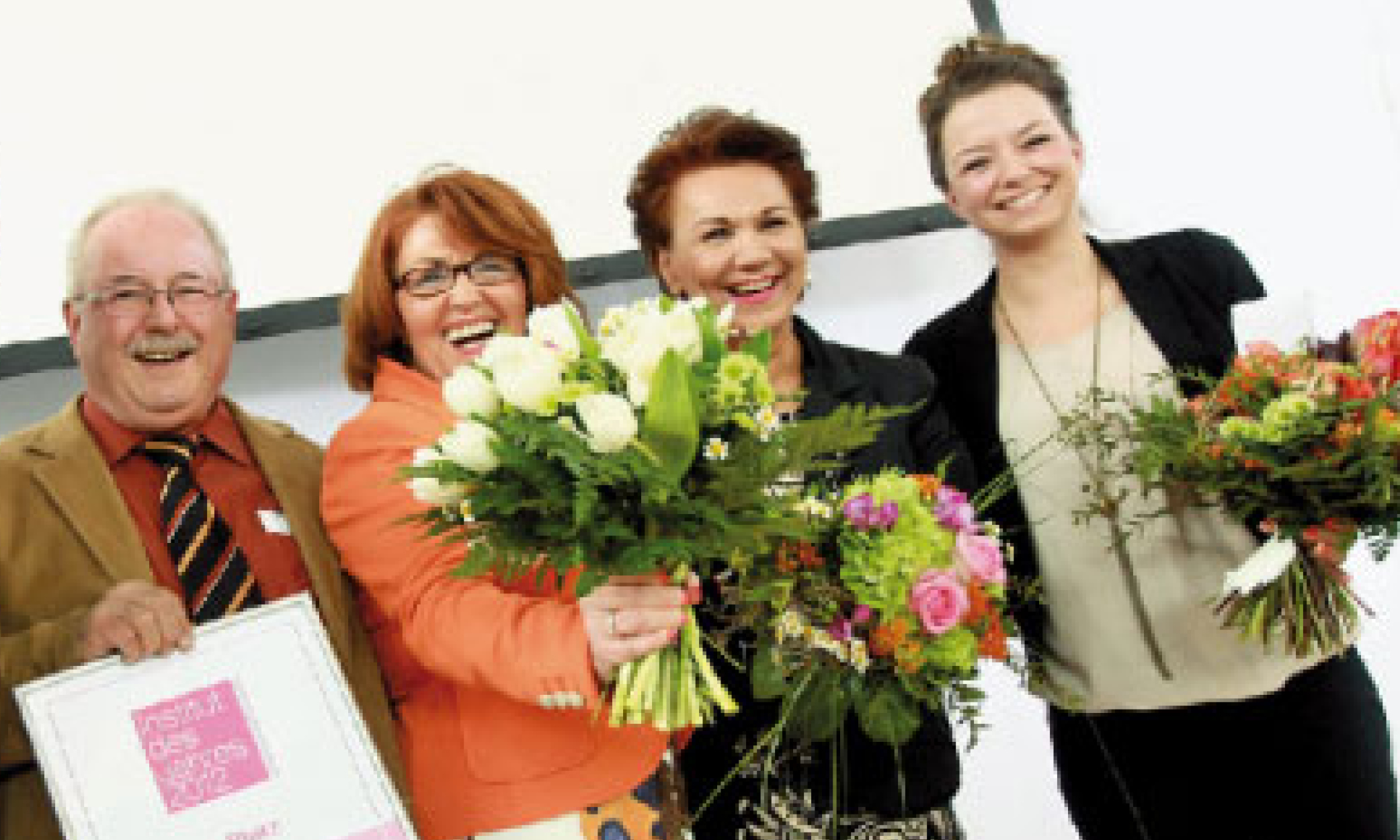 Teambild mit Blumensträußen in der Hand
