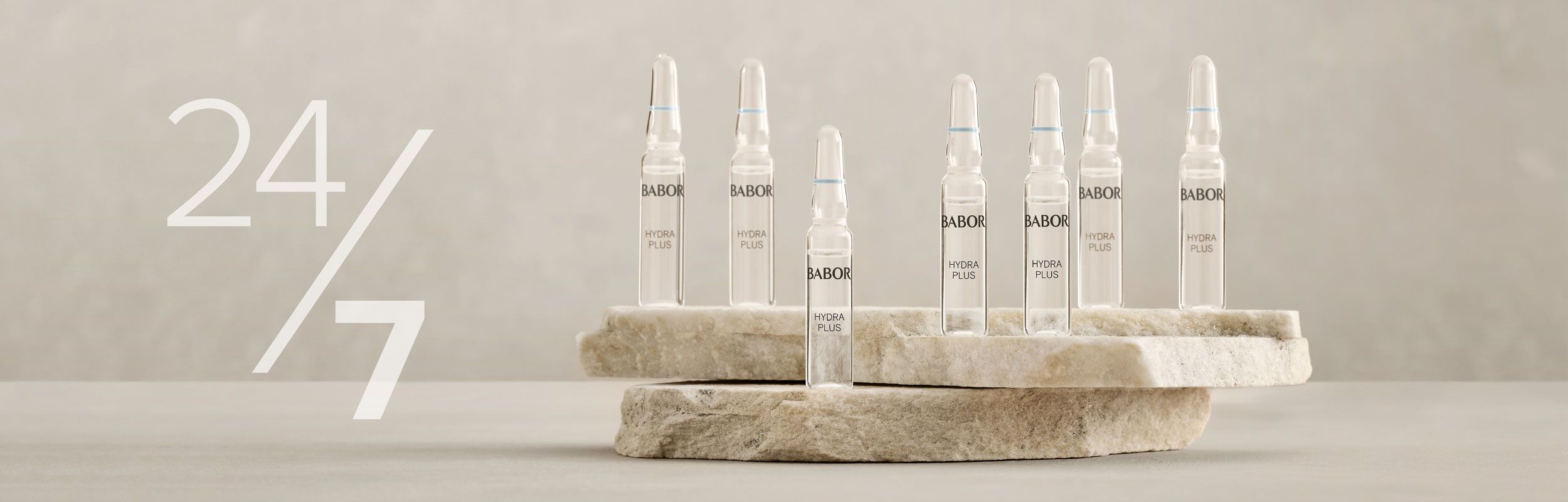 Sieben BABOR Hydra Plus Ampullen stehen auf zwei übereinanderliegenden Steinen